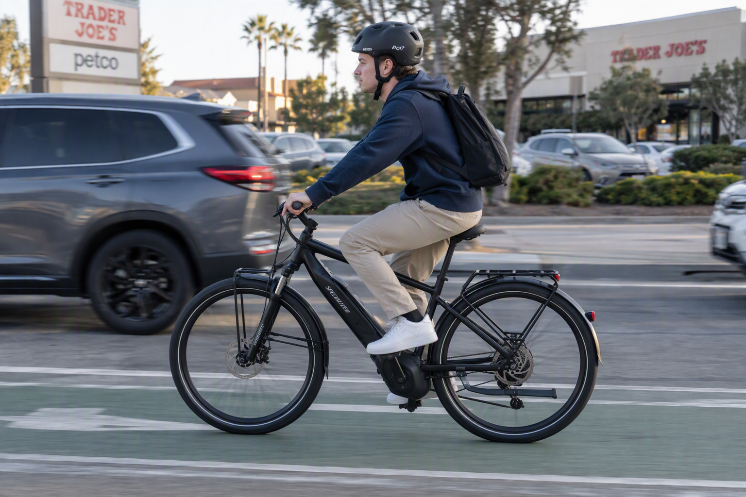 College age male riding an e-bike on a city street
